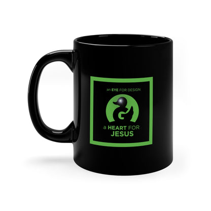 Black ceramic coffee mug with green "an EYE FOR DESIGN a HEART FOR JESUS" design and comfortable handle